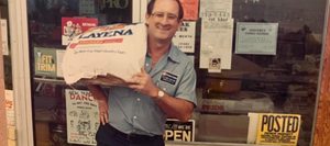 An old photo of an Old Time Farm Supply customer carrying feed over his shoulder.